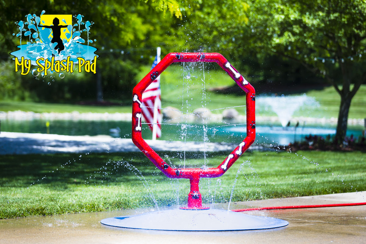 Dog Jump Hoop Water Park Feature by My Portable Splash Pad – red octagon-shaped hoop with bone and paw print design on white background.