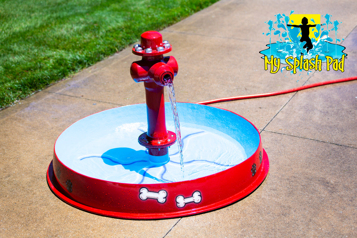 A red dog bowl with a hydrant-style water play feature, designed for outdoor water play by My portable splash pad.