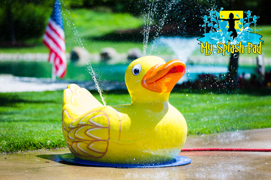 Duck Mobile Spray and Play Features – bright yellow duck splash pad water play feature spraying streams of water outdoors.