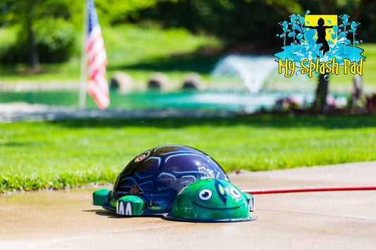 Small Turtle Mobile Splash Pad water play feature installed on outdoor splash pad with smiling turtle face and spray jets.