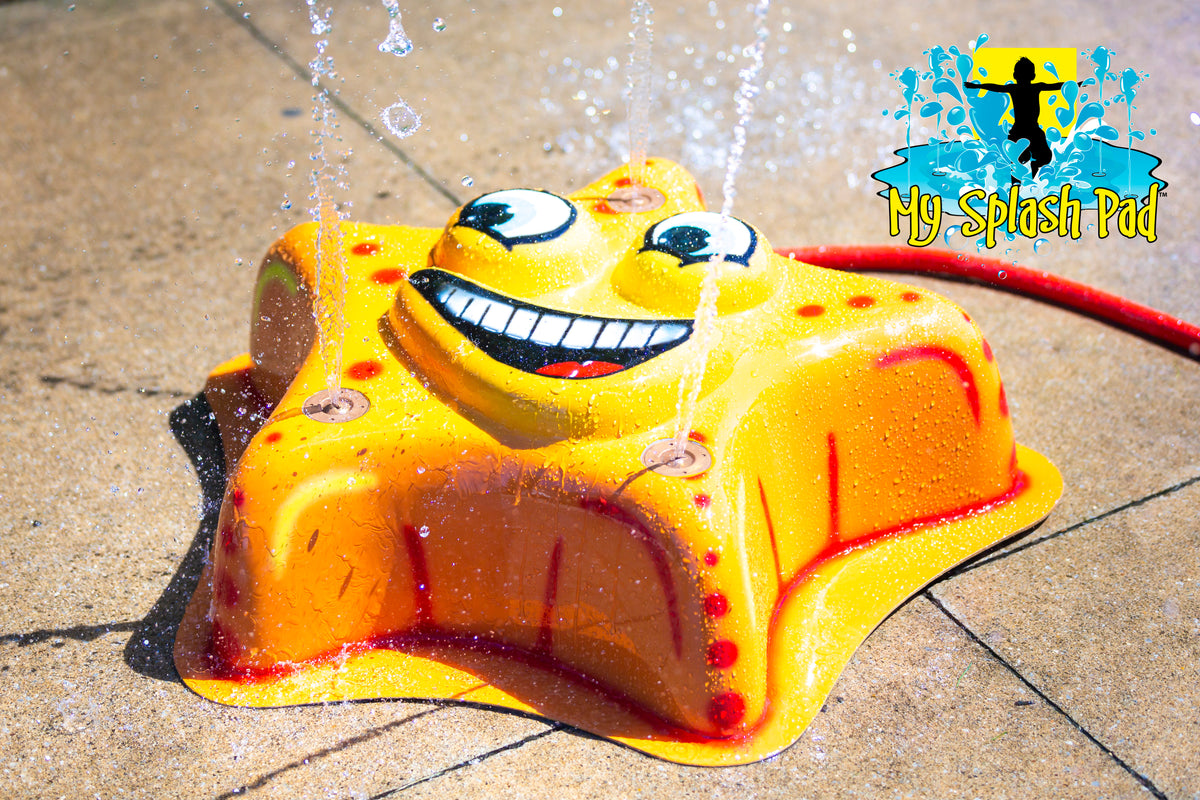 Starfish Mobile Spray and Play Features – yellow starfish splash pad spraying water jets in a backyard play area.